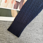 Navy cable-knit cardigan sleeve with ribbed cuff and textured knit body
