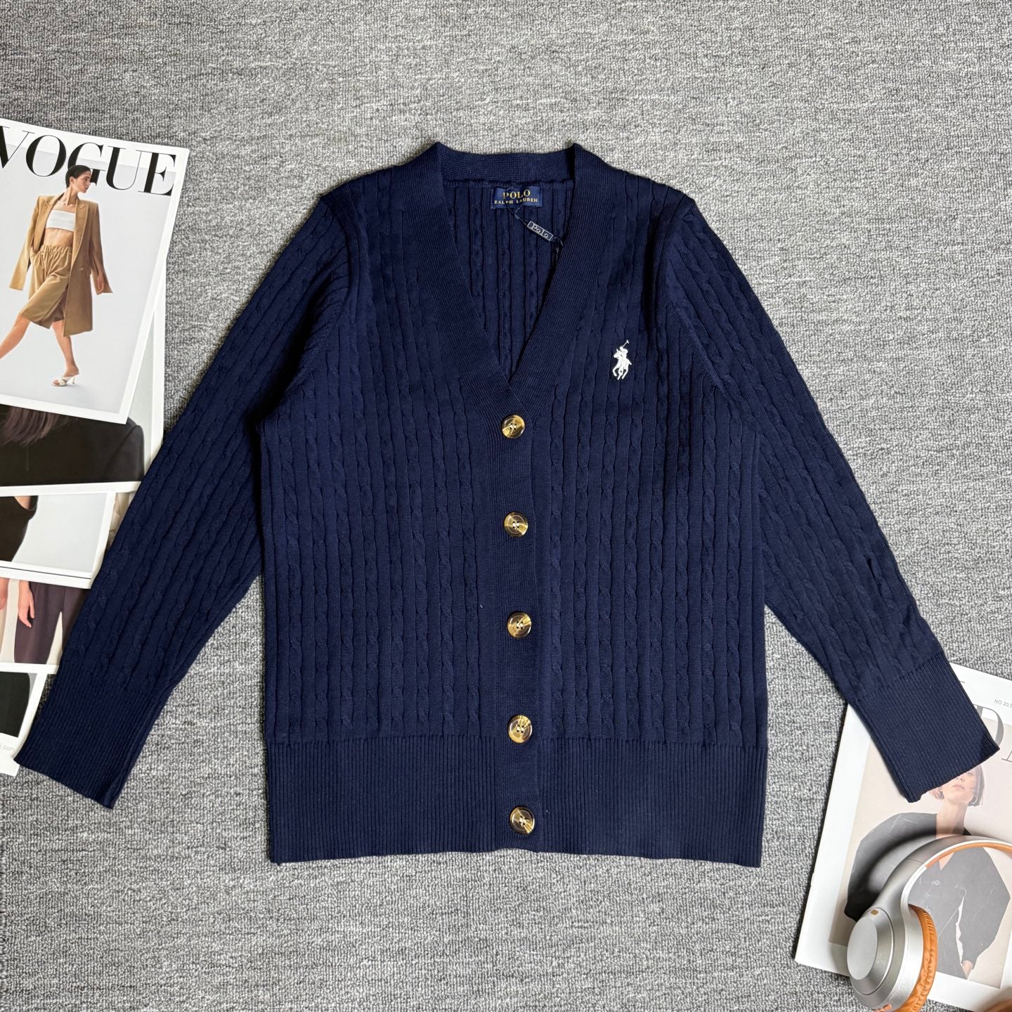 Navy cable-knit cardigan with front button placket and small polo horse emblem