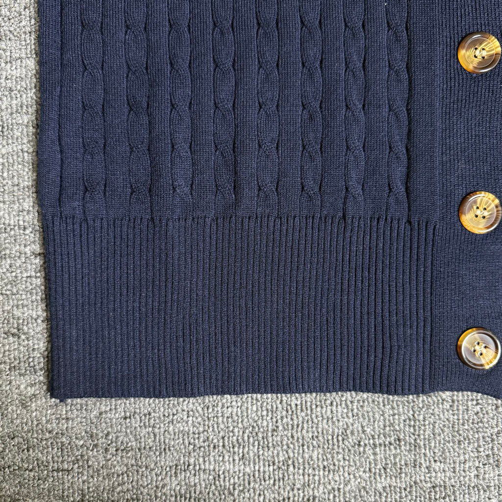 Navy cardigan bottom hem with ribbed trim and gold-tone buttons