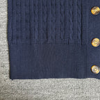 Navy cardigan bottom hem with ribbed trim and gold-tone buttons