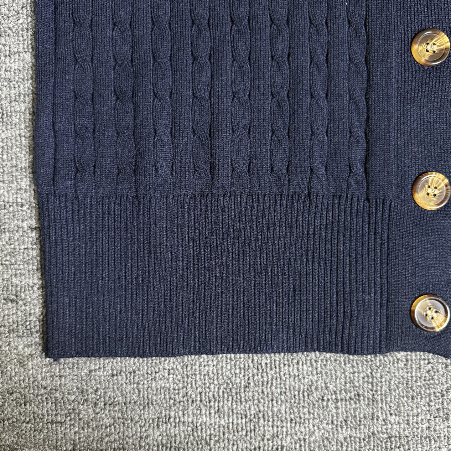 Navy cardigan bottom hem with ribbed trim and gold-tone buttons