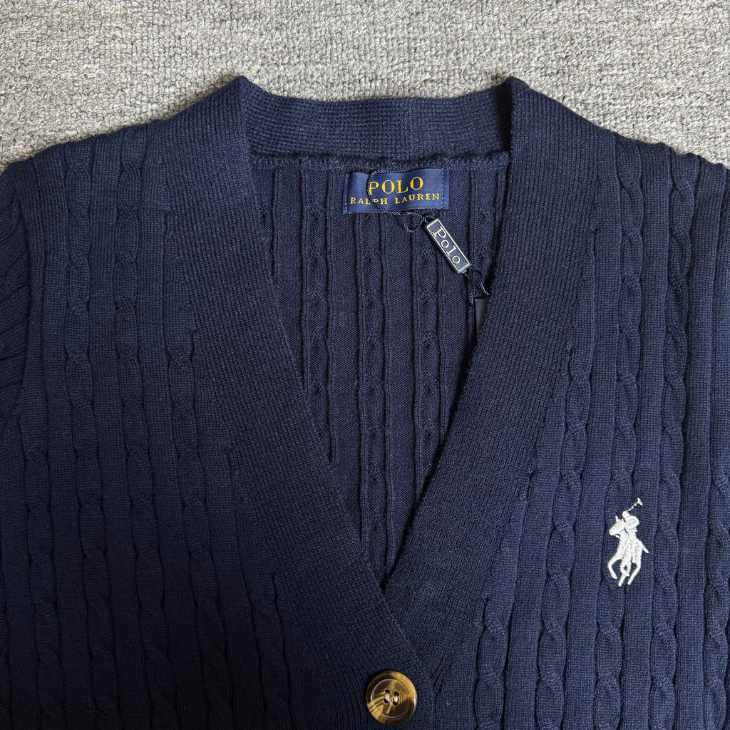 Navy knit cardigan close-up with polo horse emblem, buttons, and neck label