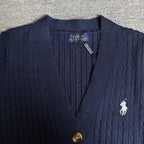 Navy knit cardigan close-up with polo horse emblem, buttons, and neck label