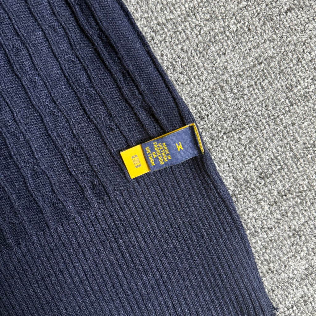 Navy knit sleeve cuff with ribbed trim and yellow size label