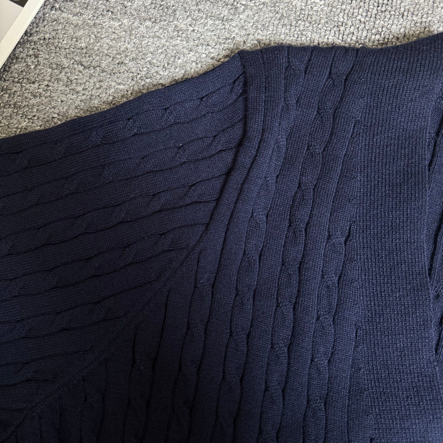Navy cable-knit cardigan shoulder and upper panel with textured ribbed pattern