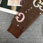 Brown Gucci logo knit cardigan sleeve cuff close-up with pink and white GG motif.