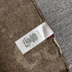 Gucci clothing label tag on brown knit fabric edge with printed care instructions.