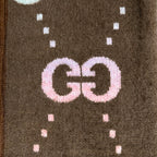 Brown Gucci logo knit cardigan close-up of GG lettering with dotted motif knit pattern.