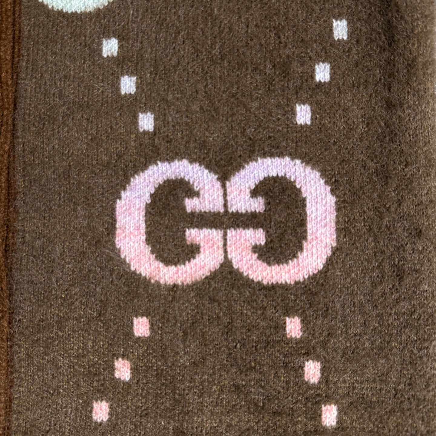 Brown Gucci logo knit cardigan close-up of GG lettering with dotted motif knit pattern.