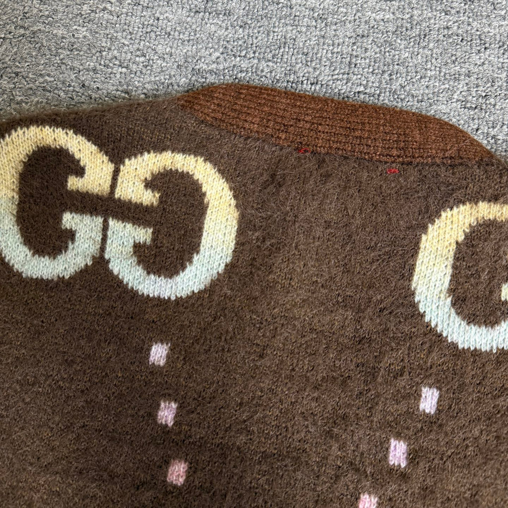 Brown Gucci logo knit cardigan upper close-up with large GG emblem and dotted pattern.