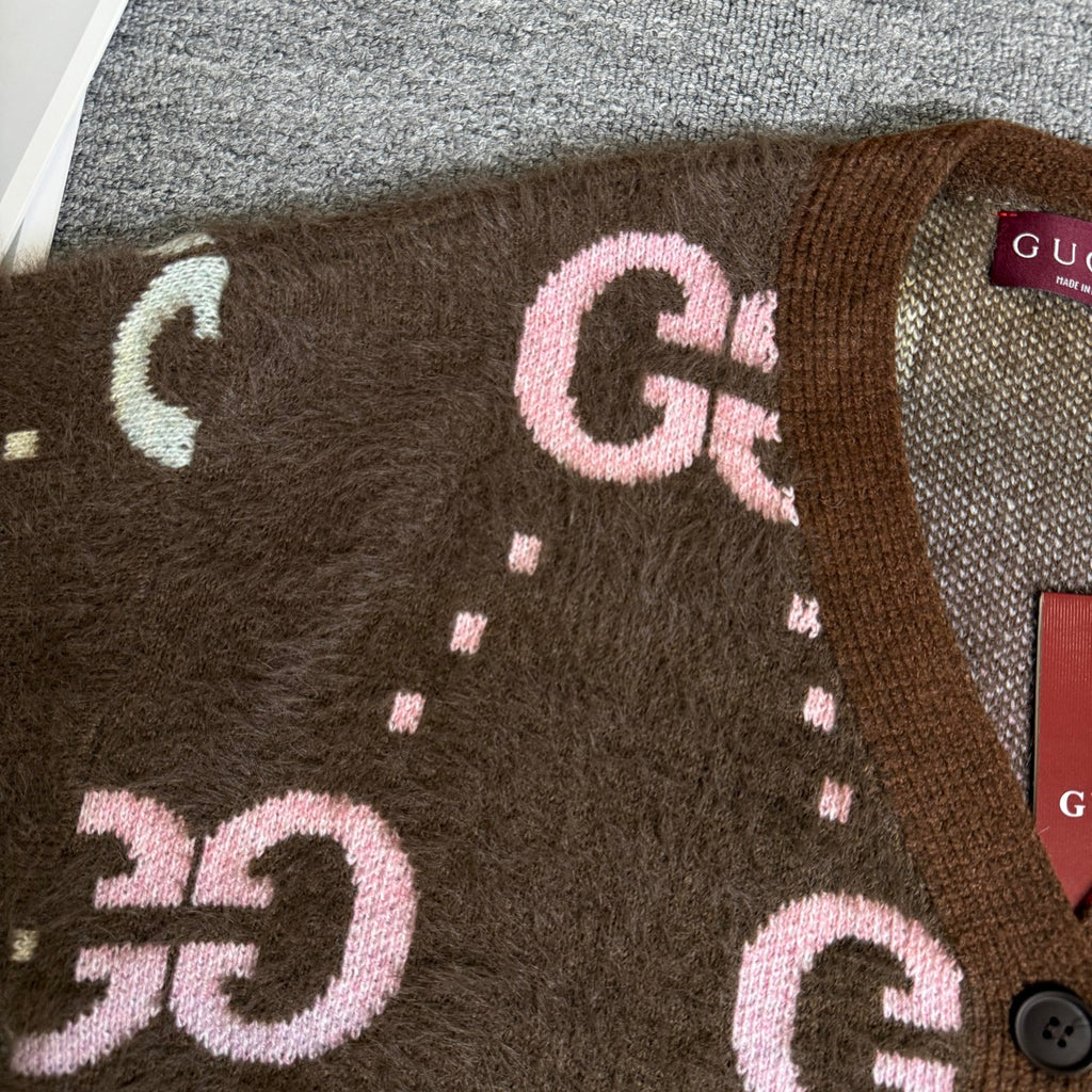 Brown Gucci logo knit cardigan close-up of oversized GG letters and dotted accents.