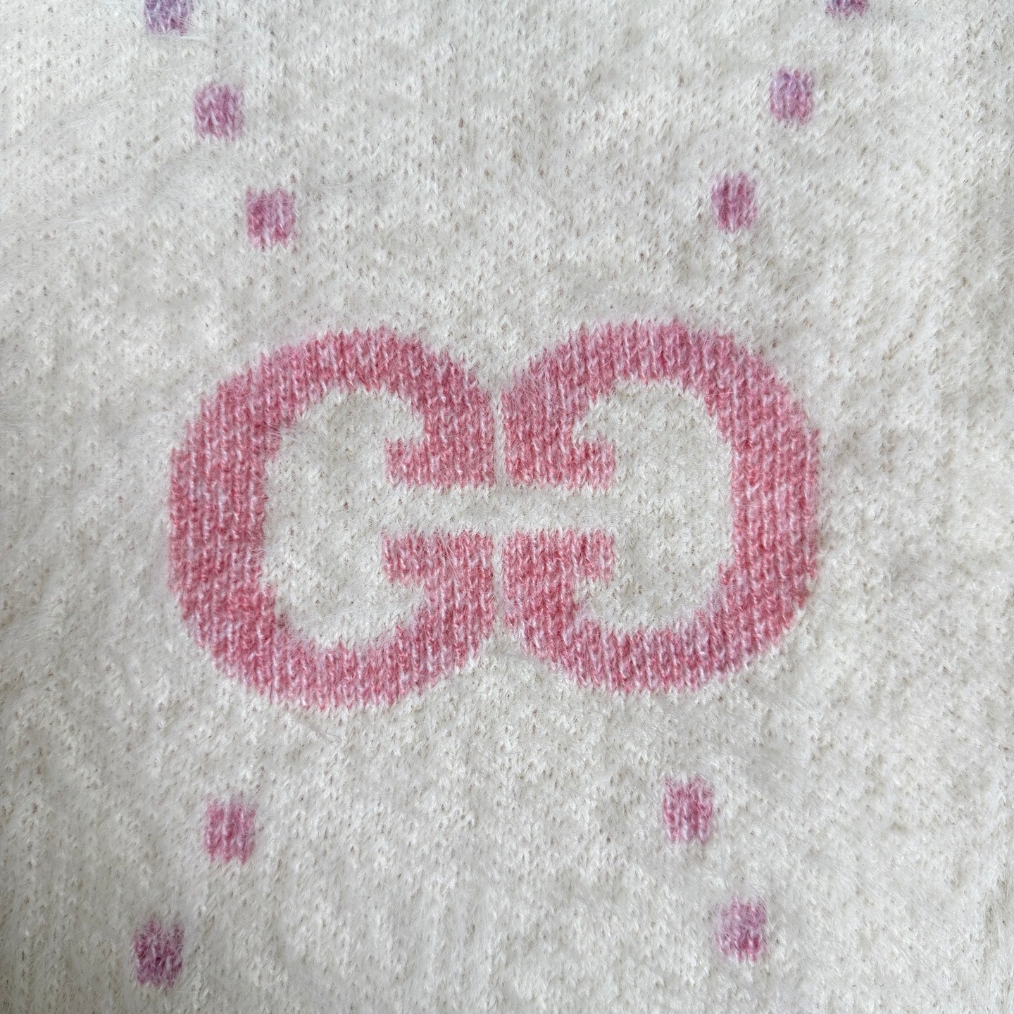 Gucci knit cardigan detail: large pink GG logo on off-white knit with small speckles