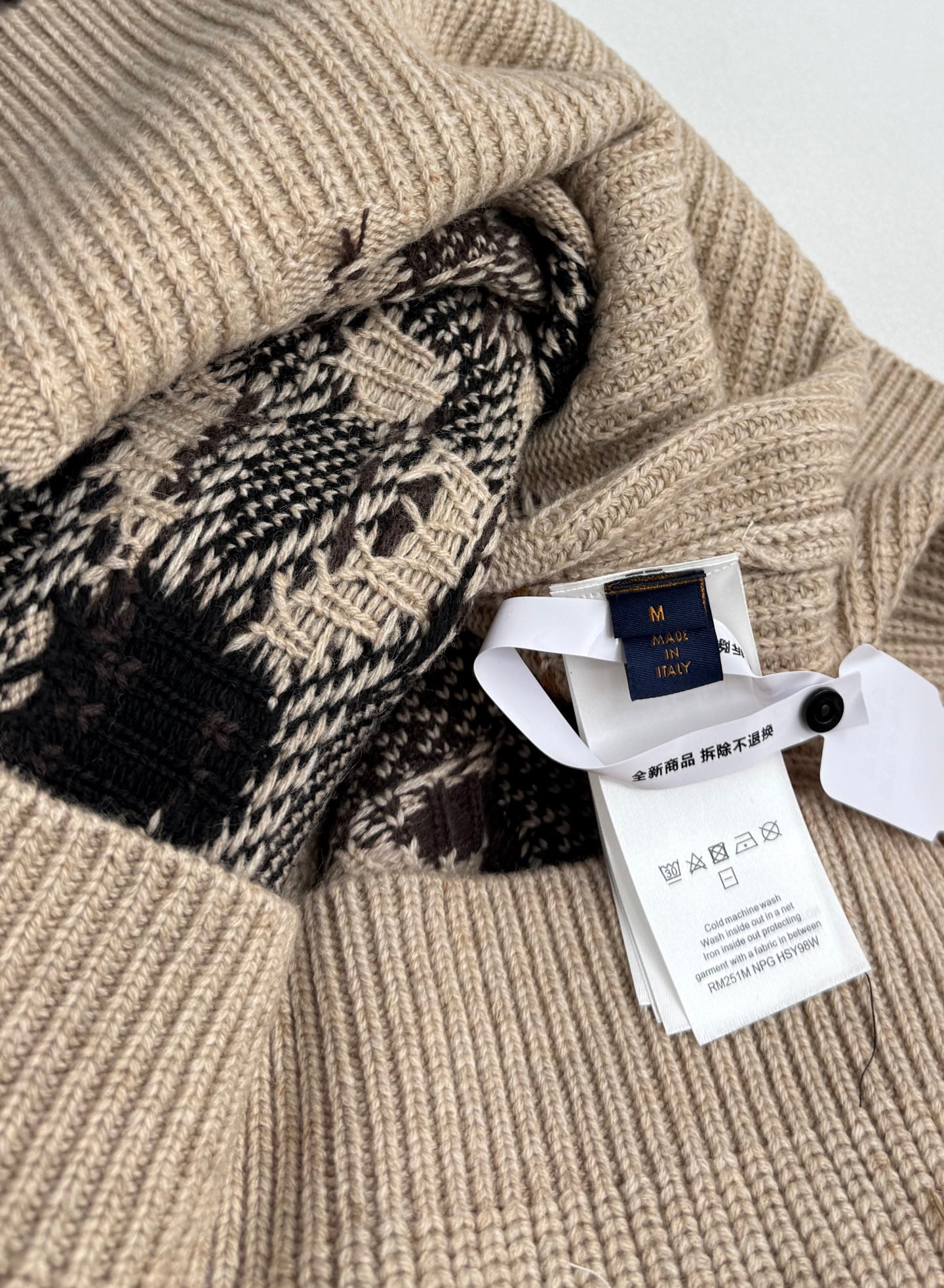 Beige knit sweater with Louis Vuitton tag and patterned cuff detail