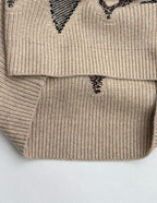 Beige knit sweater hem with black geometric intarsia design