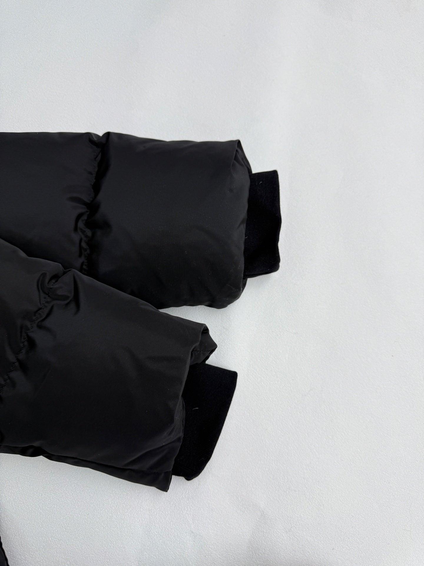 Black puffer jacket sleeve cuffs with elastic at wrist openings