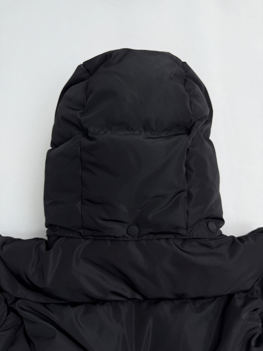 Black long puffer jacket hood and shoulder area with buttoned neck
