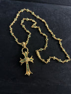 Gold-tone cross pendant necklace with green stone accents, chain loop clasp
