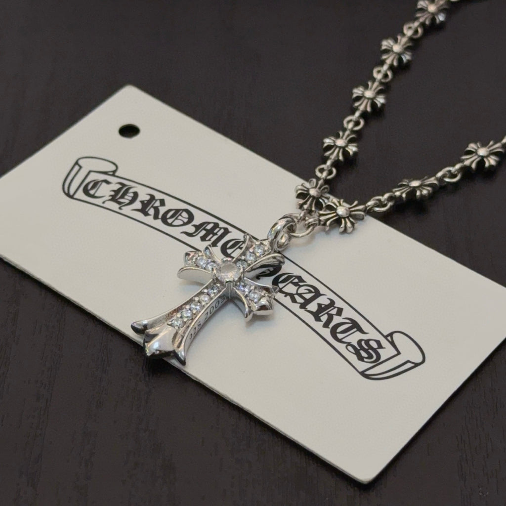 Silver-tone cross pendant necklace with jeweled cross and decorative chain