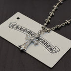 Silver-tone cross pendant necklace with jeweled cross and decorative chain
