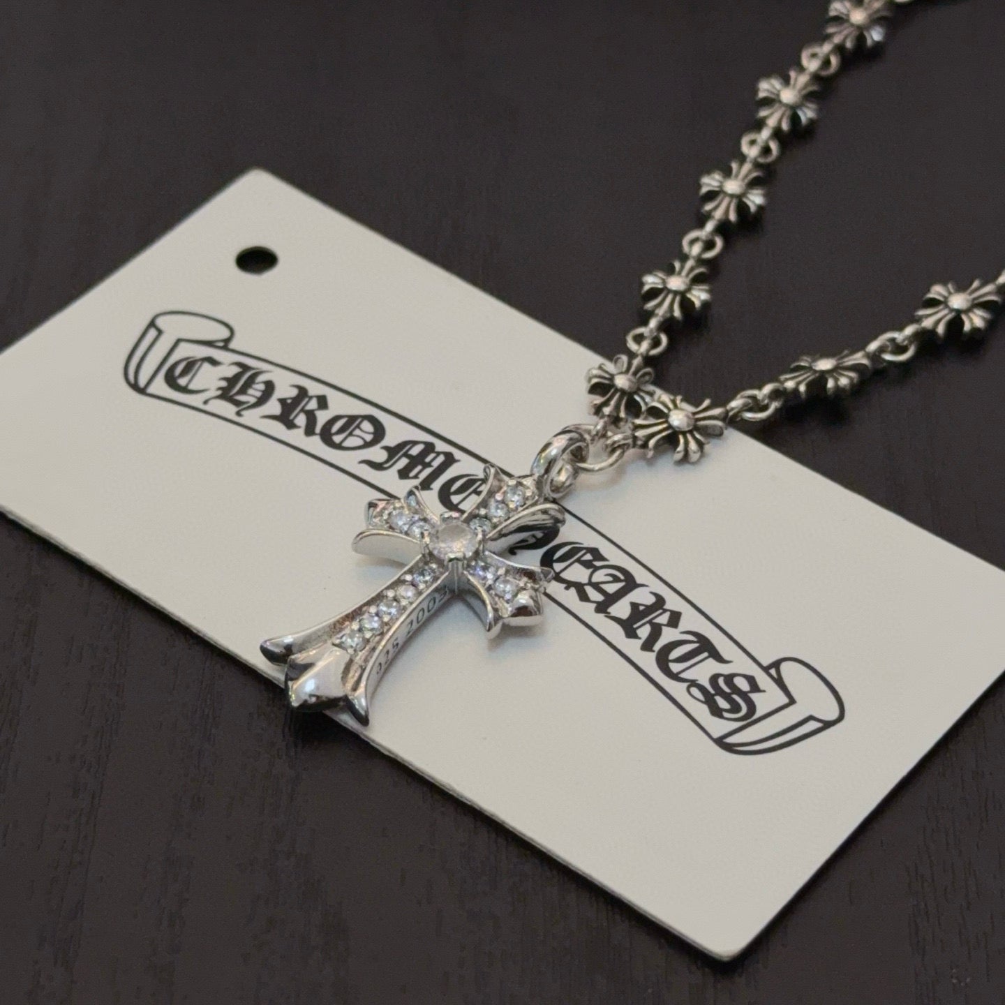 Silver-tone cross pendant necklace with jeweled cross and decorative chain