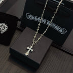 Silver-tone cross pendant necklace with ornate floral chain and dangling cross