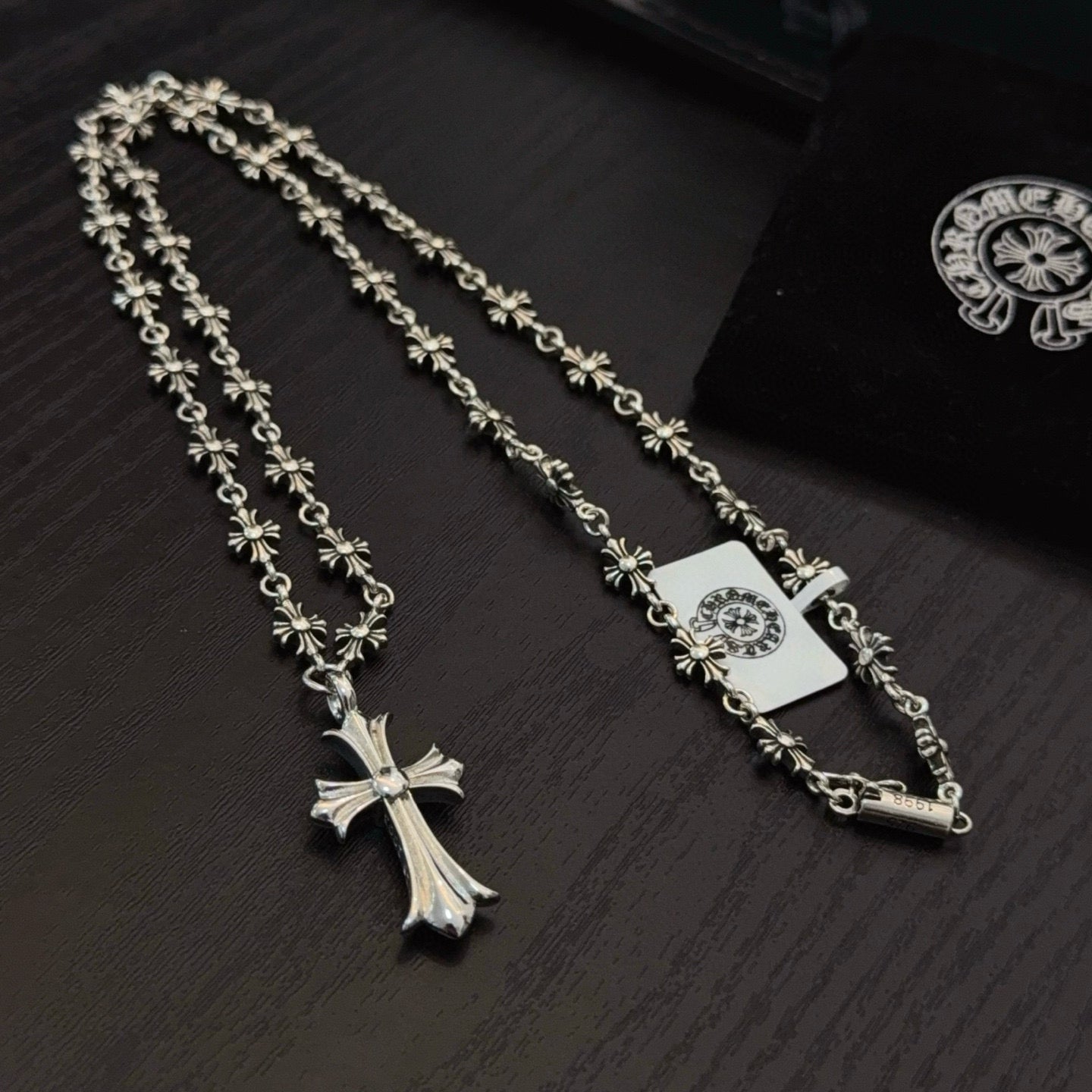 Two silver-tone cross pendant necklaces with floral chain links