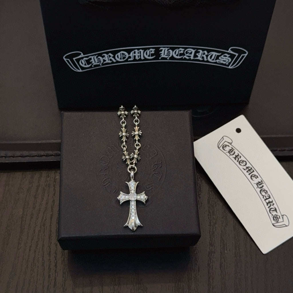 Silver-tone cross pendant necklace with faceted cross and long decorative chain