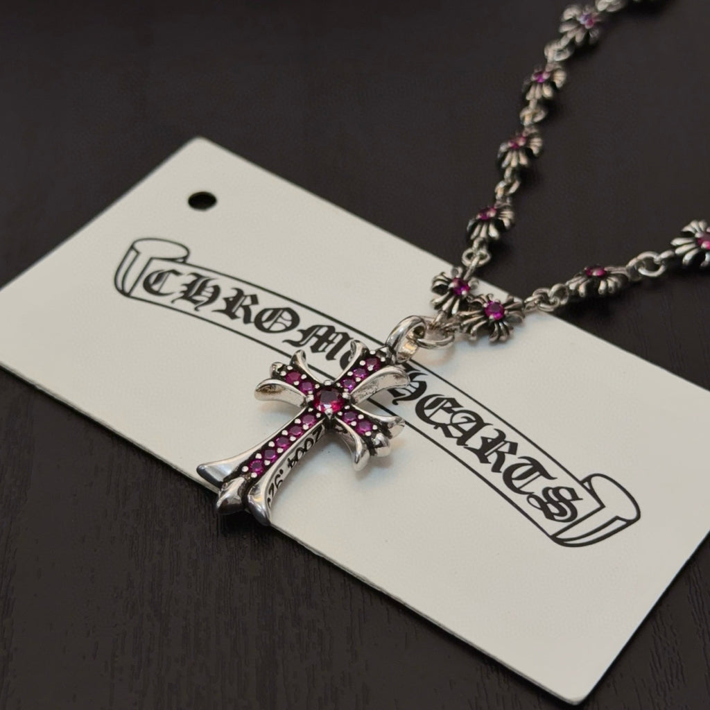 Silver-tone cross pendant with pink crystal accents on a beaded chain