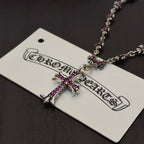 Silver-tone cross pendant with pink crystal accents on a beaded chain