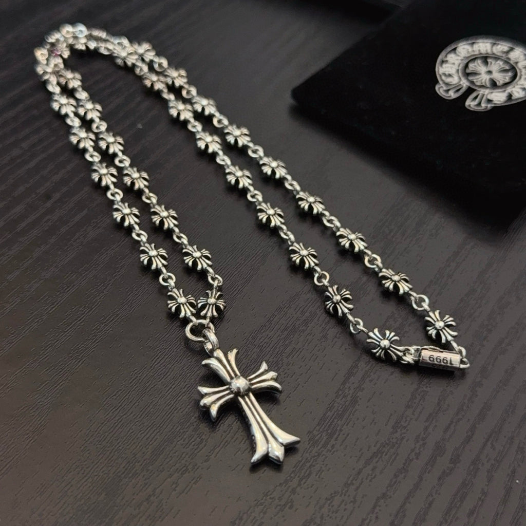 Silver-tone cross pendant necklace with ornate bead chain and pink crystal accents