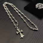 Silver-tone cross pendant necklace with ornate bead chain and pink crystal accents