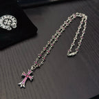 Silver-tone cross pendant necklaces with pink crystal details, two strands shown