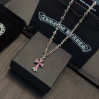 Silver-tone cross pendant necklace with pink crystal details and ornate bead chain