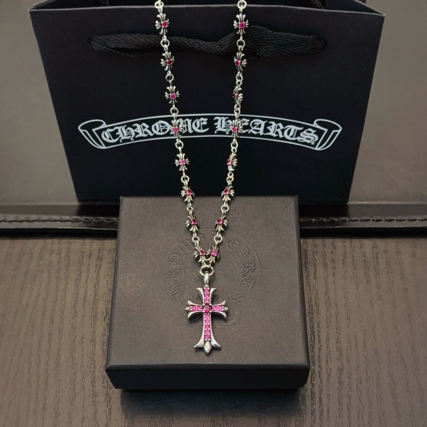 Silver-tone cross pendant necklace with pink crystal center and chain links