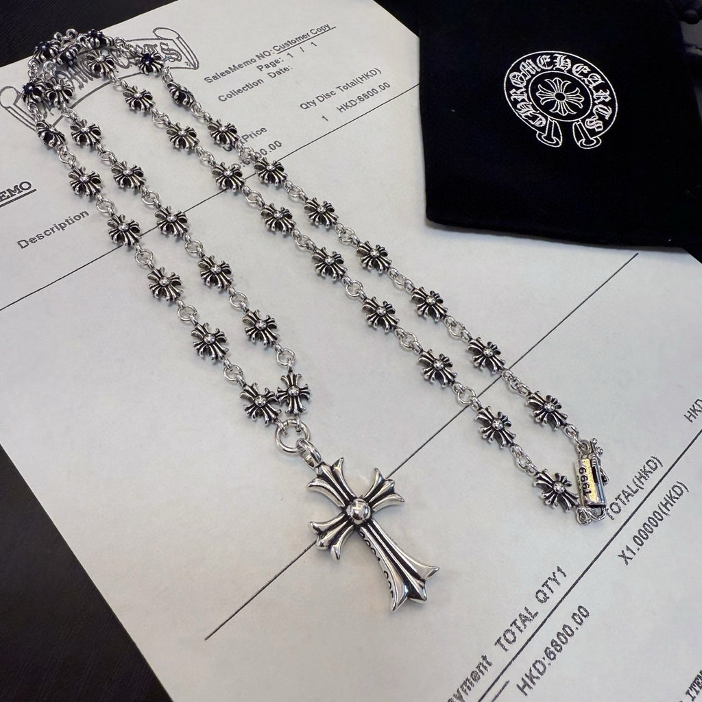 Silver-tone cross pendant necklace with blue inlay, shown with chain detail on card.