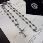 Silver-tone cross pendant necklace with blue inlay, shown with chain detail on card.