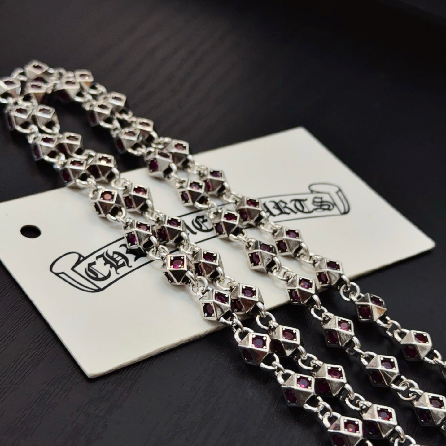 Silver cross pendant necklace with square purple stone accents and chain links