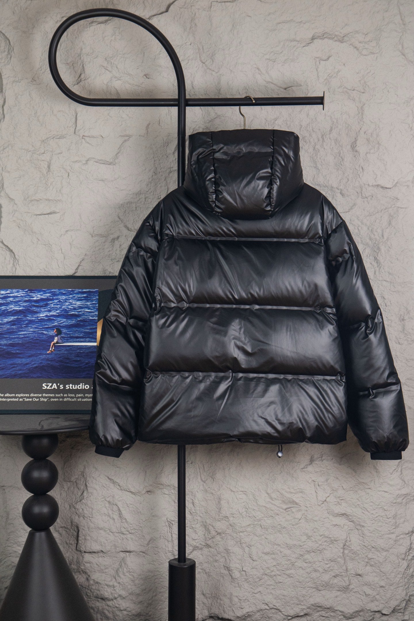Long puffer jacket with raised hood, dark padded quilted panels and front zip