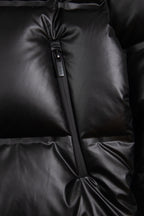 Dark puffer jacket front seam detail with center zipper and quilted panels