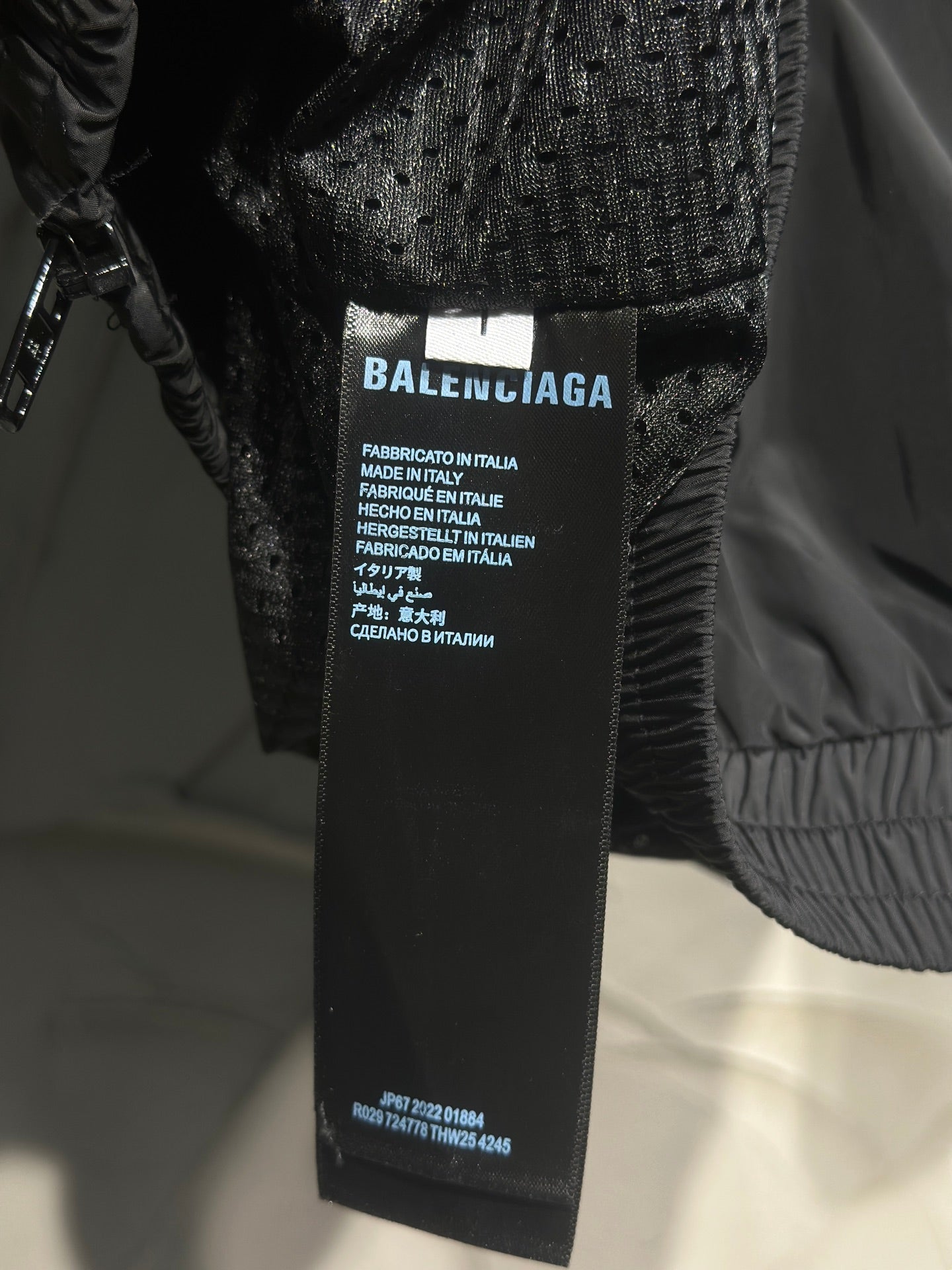 Black track jacket with interior size and care label tag