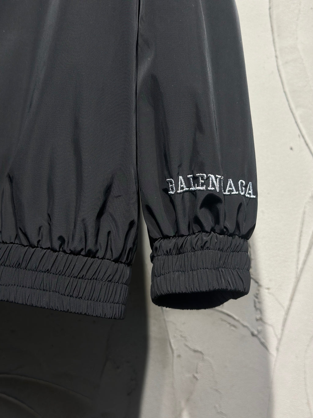 Black track jacket sleeve cuff with elastic hem and small Balenciaga logo