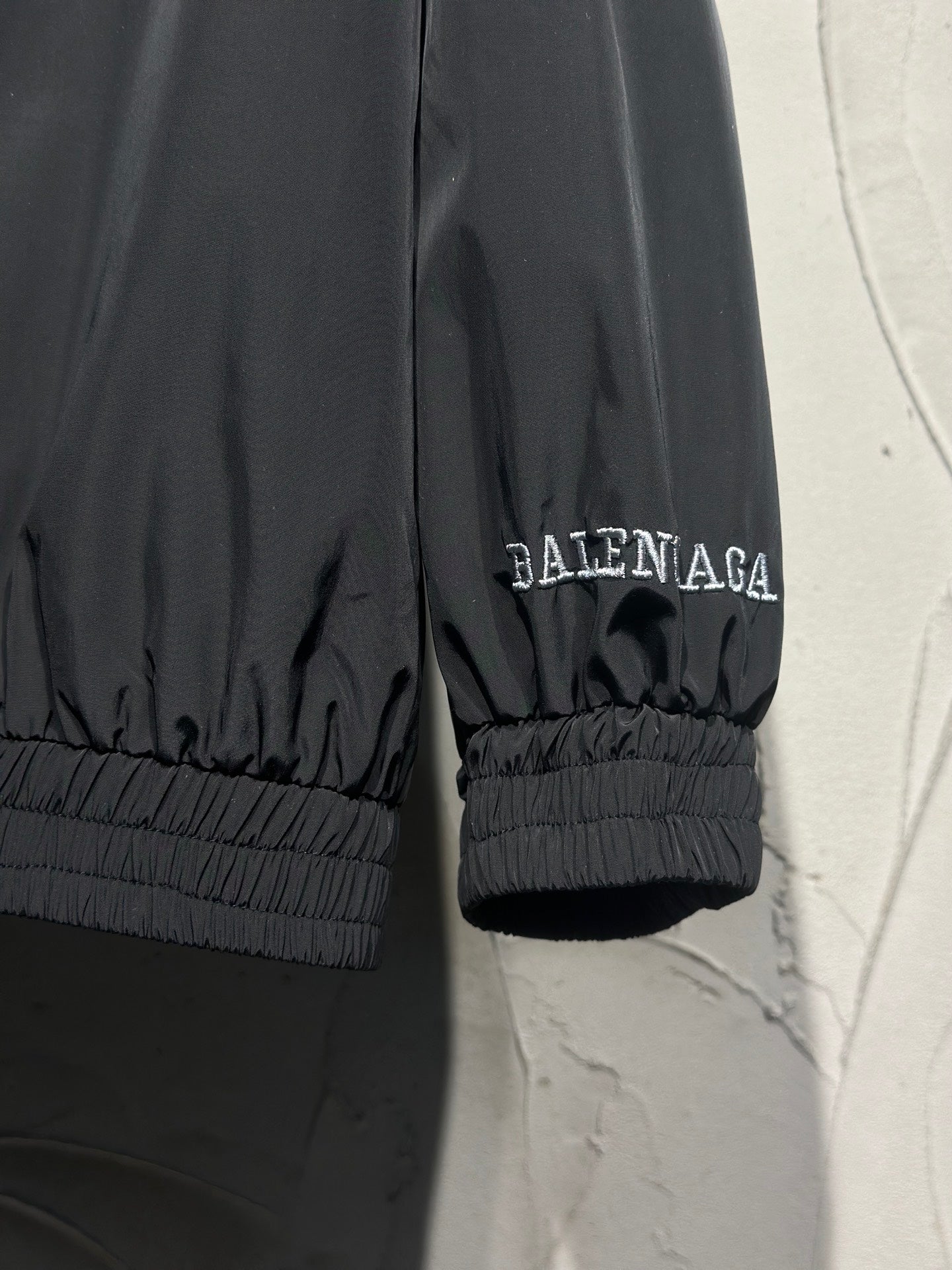 Black track jacket sleeve cuff with elastic hem and small Balenciaga logo