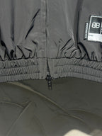Black track jacket hem with gathered elastic and front zipper
