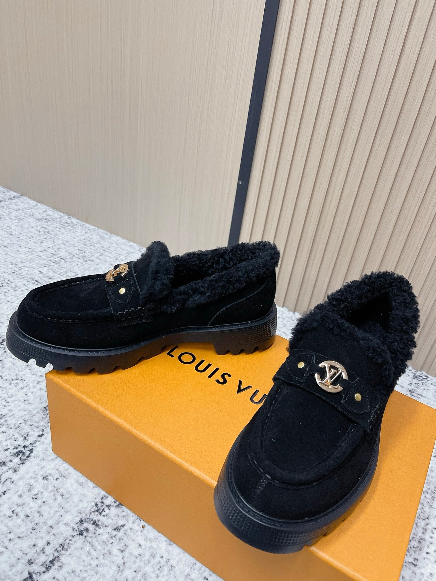 Dark suede shearling loafer shoes with gold logo detail on top strap