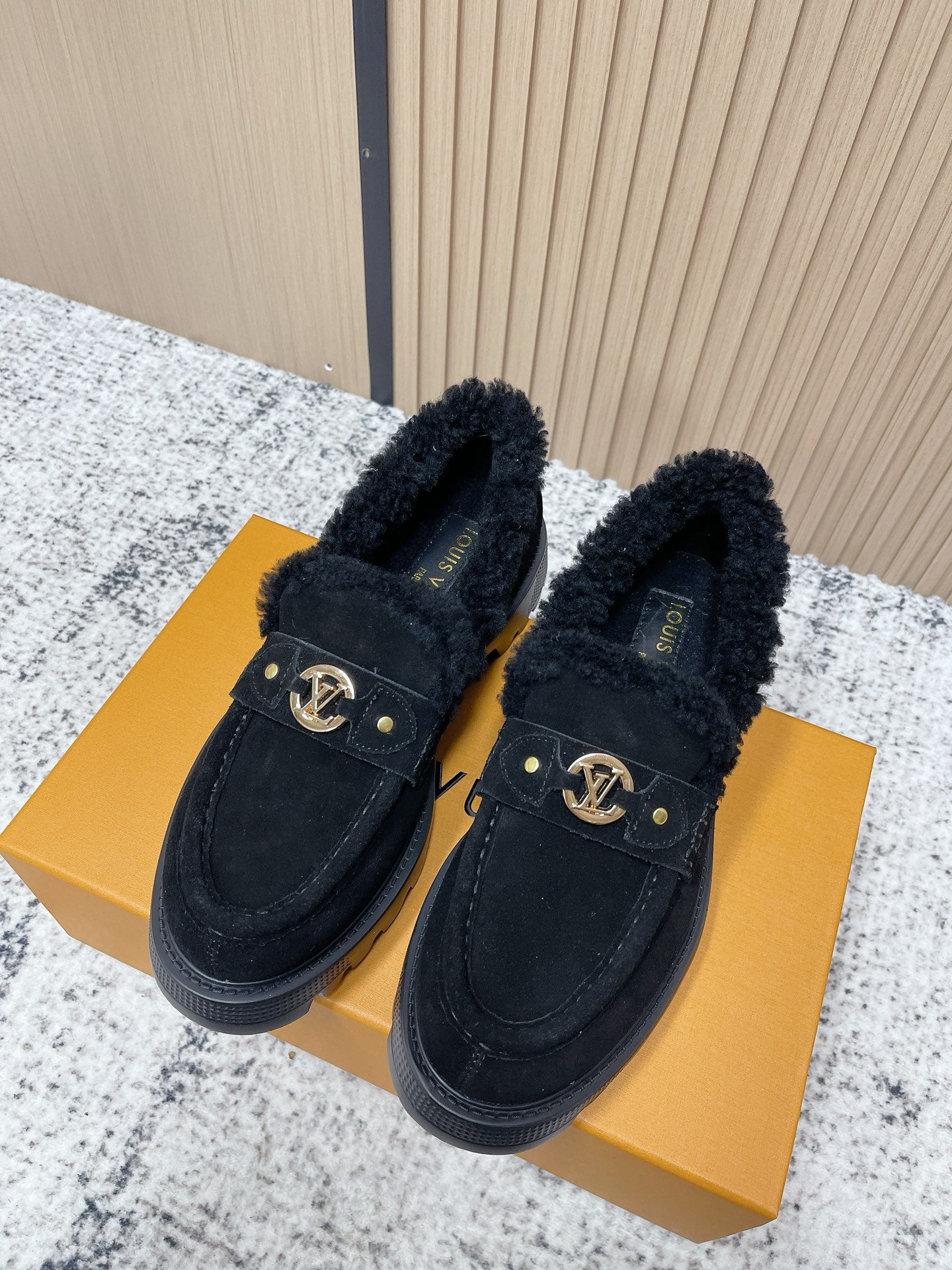 Dark suede shearling-lined loafer shoes with gold logo buckle and low rubber sole