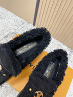 Shearling-lined interior of dark suede loafer shoes with printed brand label