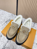 Beige suede slip-on shoes with white shearling lining and gold buckle detail