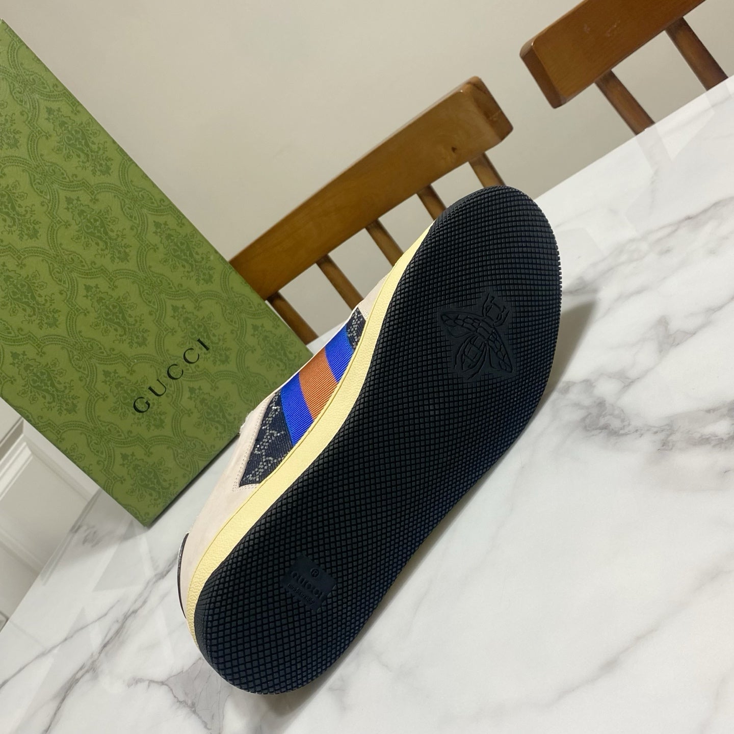 Gucci unisex sneaker sole view, textured dark outsole with cream sidewall edge