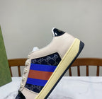 Gucci unisex sneaker side close-up, cream leather with navy toe and multicolor stripe