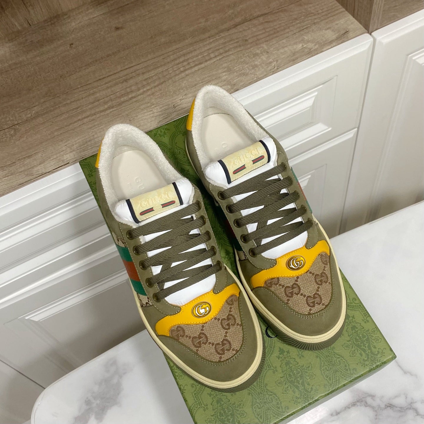 Low-top unisex sneakers with olive uppers, GG trim, multicolor stripe, and lace-up design